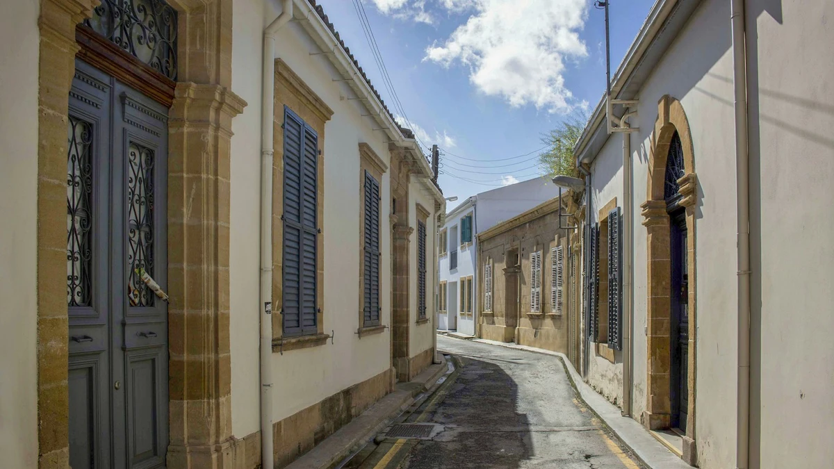 Narrow street in the old town of Nicosia with limestone door frames and blue wooden shutters