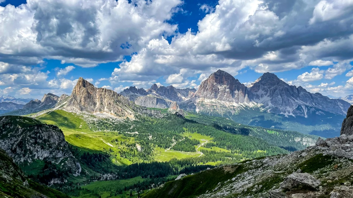 Dolomite peaks and forested valleys in northern Italy under a summer sky