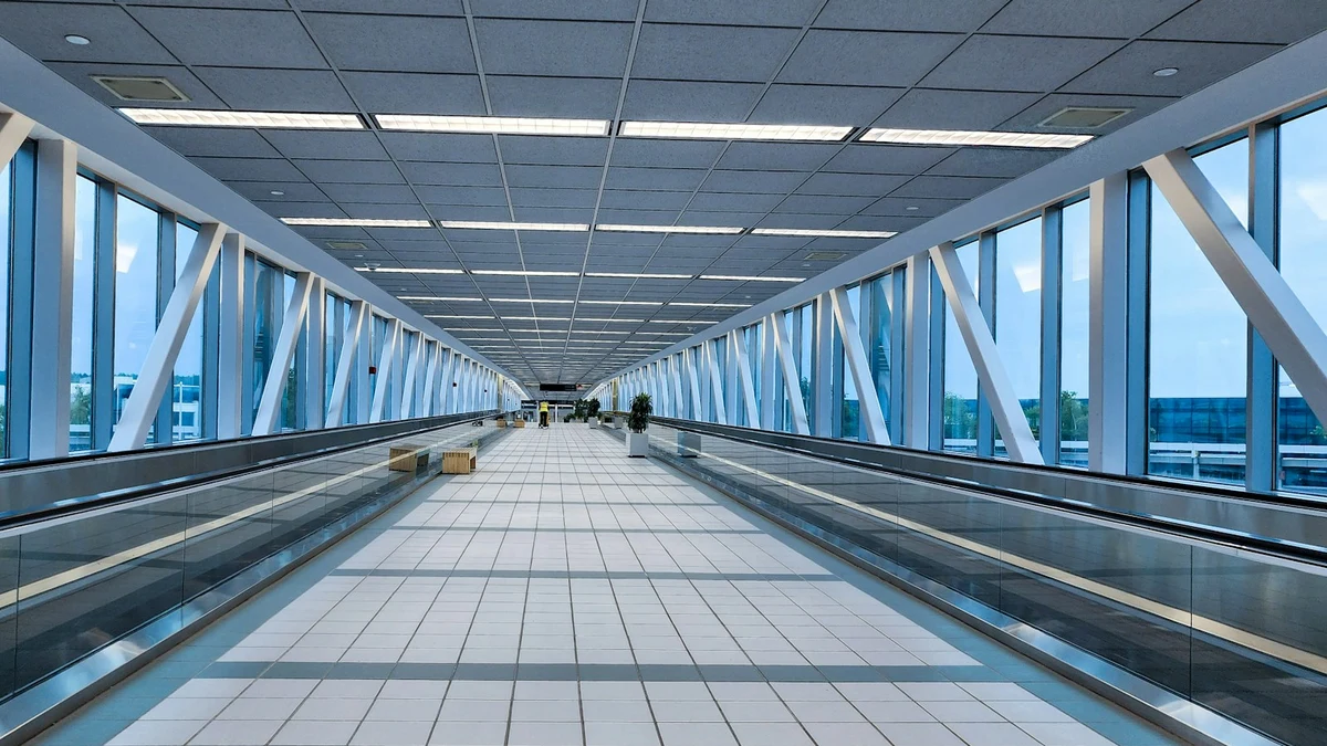 An empty glass transfer corridor with moving walkways running down both sides
