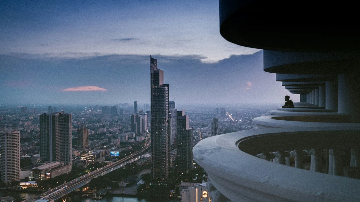 Bangkok towers and the river at dusk, seen from a high balcony