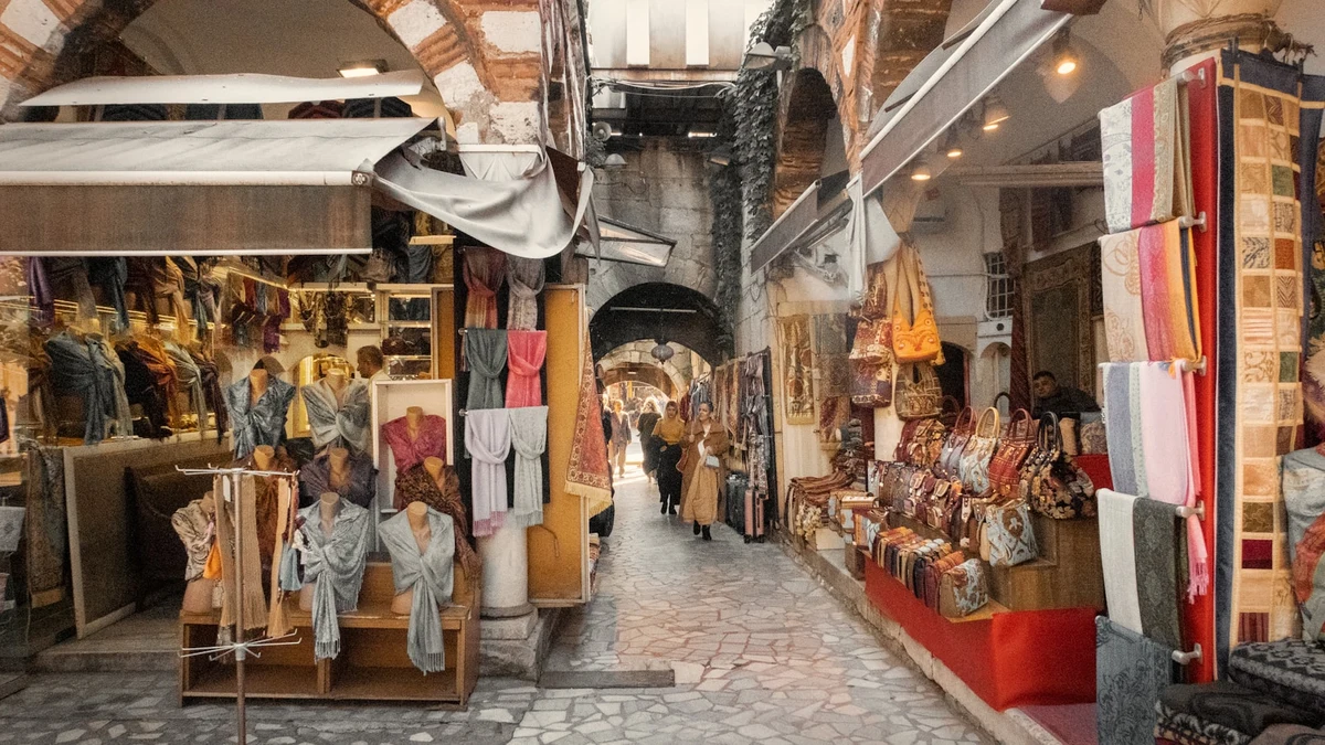 A covered bazaar arcade in Istanbul lined with textile and leather stalls