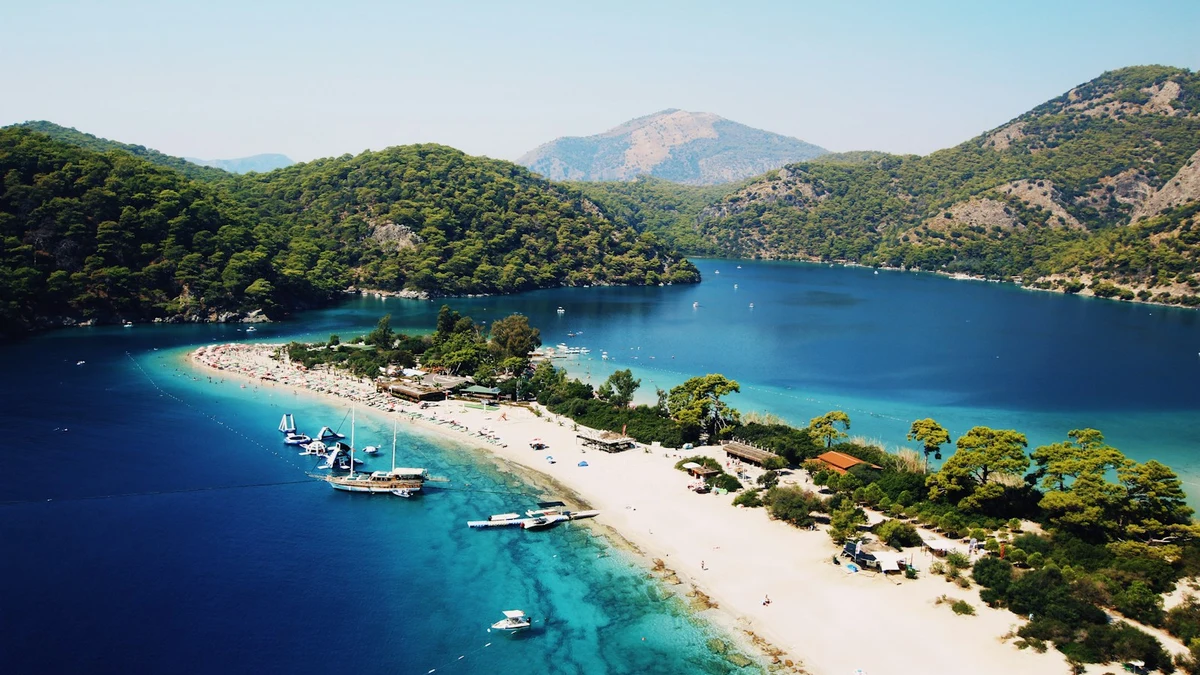 Aerial view of a turquoise lagoon and pine-covered headland on the Turkish Mediterranean coast
